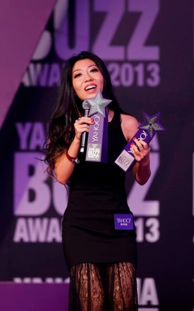 FILE - In this Dec. 1, 2013 file photo, Chinese singer-songwriter Wanting Qu holds two trophies after winning Hong Kong Most Popular Singer-Songwriter and the Best Mandarin Song at the Yahoo Buzz Awards in Hong Kong. A Chinese pop star whose mother had been held in custody since being arrested for corruption six years ago said that the charge had been removed by Chinese prosecutors. (AP Photo/Kin Cheung, File)