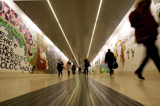 Few people walk in the Garibaldi subway station at rush hour, in Milan, Friday, Feb. 28, 2020. Due to the COVID-19 virus outbreak in northern Italy, the bustling metropolis of Milan has resembled more of a ghost town lately, as workers stayed home and tourism has dwindled there, and other parts of Italy. (AP Photo/Luca Bruno)