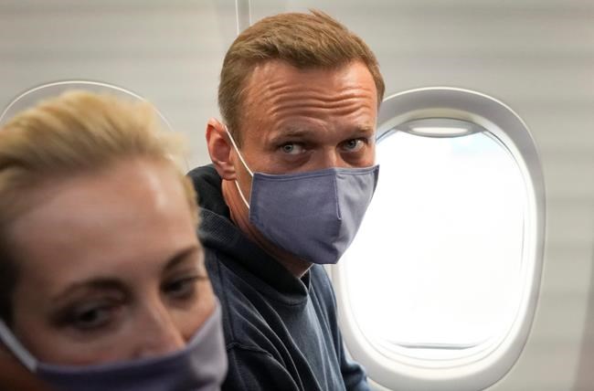 Alexei Navalny and his wife, Yulia sit in the plane prior to their flight to Moscow in the Airport Berlin Brandenburg (BER) in Schoenefeld, near Berlin, Germany, Sunday, Jan. 17, 2021. Leading Kremlin critic Alexei Navalny plans to fly home to Russia on Sunday after recovering in Germany from his poisoning in August with a nerve agent. (AP Photo/Mstyslav Chernov)