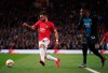 Manchester United's Bruno Fernandes, left, and Brugge's Simon Deli run for the ball during the round of 32 second leg Europa League soccer match between Manchester United and Brugge at Old Trafford in Manchester, England, Thursday, Feb. 27, 2020. (AP Photo/Dave Thompson)