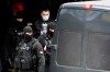 Serbian police officers escort detained Partizan fan leader Veljko Belivuk, centre, during a raid on Partizan stadium, in Belgrade, Serbia, Thursday, Feb. 4, 2021. Belivuk, also known as Velja Nevolja or Velja the Trouble, was often linked to criminal activity but reportedly managed to stay free because of his connections with politicians. Serbian police raided the stadiums of the country's two biggest soccer clubs on Thursday after arresting 17 people linked to fan groups accused of organized crime, drug trafficking and murder. (AP Photo/Darko Vojinovic)