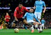 Manchester United's Marcus Rashford, left, duels for the ball with Manchester City's Bernardo Silva during the English Premier League soccer match between Manchester City and Manchester United at Etihad stadium in Manchester, England, Saturday, Dec. 7, 2019. (AP Photo/Rui Vieira)