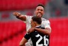 Arsenal's Pierre-Emerick Aubameyang, top, celebrates with Arsenal goalkeeper Emiliano Martinez after scores the winning penalty in a penalty shootout at the end of the English FA Community Shield soccer match between Arsenal and Liverpool at Wembley stadium in London, Saturday, Aug. 29, 2020. (Andrew Couldridge/Pool via AP)