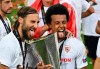 Sevilla's Nemanja Gudelj, left, and Sevilla's Franco Vazquez pose with the trophy after winning the Europa League final soccer match between Sevilla and Inter Milan in Cologne, Germany, Friday, Aug. 21, 2020. (Ina Fassbender/Pool via AP)