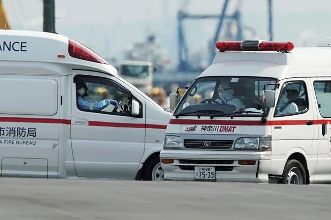 Officials in protective suits drive ambulances near the cruise ship Diamond Princess anchored at Yokohama Port in Yokohama, near Tokyo. Friday, Feb. 7, 2020. Japan on Friday reported 41 new cases of a virus on the cruise ship that's been quarantined. About 3,700 people have been confined aboard the ship. (AP Photo/Eugene Hoshiko)