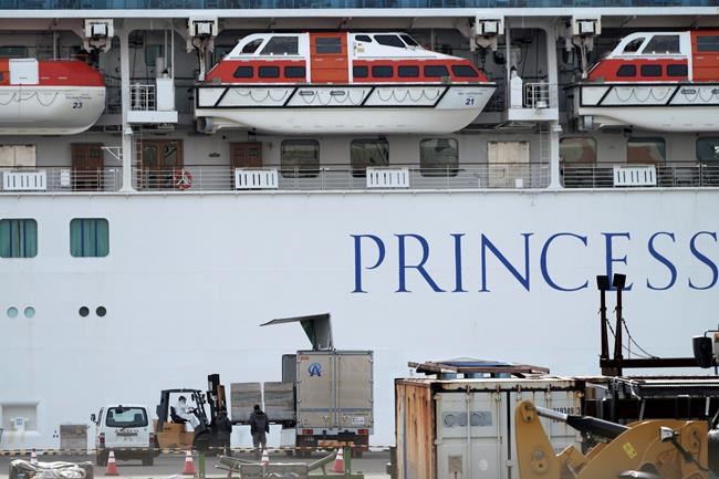 Officials and staffs unload supplies for the cruise ship Diamond Princess anchored at the Yokohama Port in Yokohama, near Tokyo Friday, Feb. 7, 2020. Japan on Friday reported 41 new cases of a virus on a cruise ship that's been quarantined in Yokohama harbor while the death toll in mainland China rose to 636, including a doctor who got in trouble with authorities in the communist country for sounding an early warning about the disease threat. (AP Photo/Eugene Hoshiko)