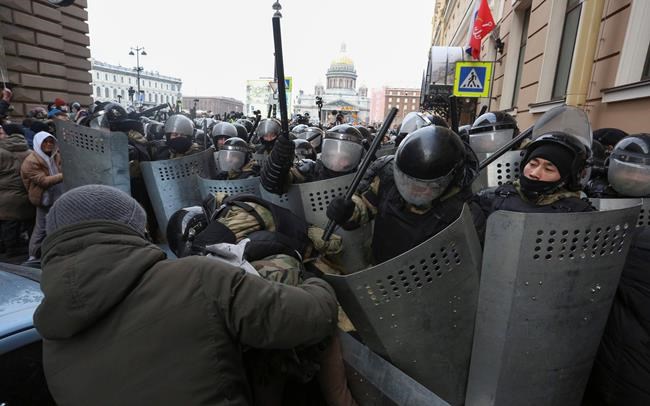 Police stand blocking approaches to the street as protesters try to break through during a protest against the jailing of opposition leader Alexei Navalny in St. Petersburg, Russia, Sunday, Jan. 31, 2021. Thousands of people have taken to the streets across Russia to demand the release of jailed opposition leader Alexei Navalny, keeping up the wave of nationwide protests that have rattled the Kremlin. Hundreds have been detained by police. (AP Photo/Valentin Egorshin)