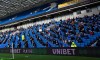 Fans, wearing a face mask, for covering due to the COVID-19 pandemic, sit socially distanced during the English Premier League soccer match between Brighton and Hove Albion and Sheffield United at the American Express Community Stadium in Brighton, England, Saturday, Dec. 20, 2020. (Glyn Kirk/Pool via AP)