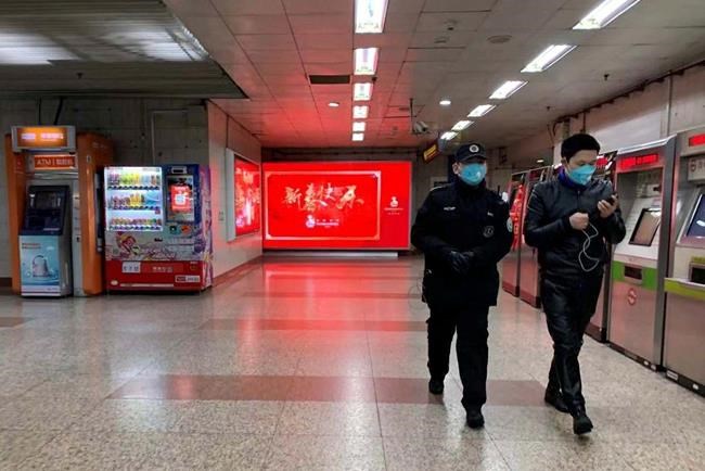 Masked residents walk through a deserted subway station in Shanghai on Sunday, Jan. 26, 2020. The new virus accelerated its spread in China, and the U.S. Consulate in the epicenter of the outbreak, the central city of Wuhan, announced Sunday it will evacuate its personnel and some private citizens aboard a charter flight. (AP Photo/Erika Kinetz)