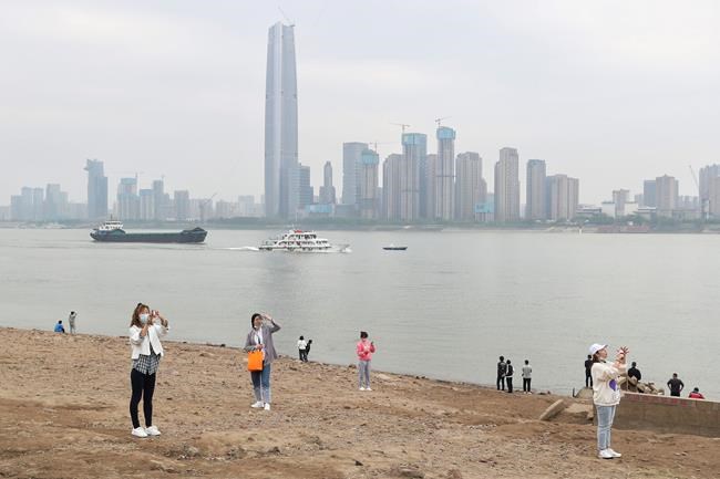 Residents visit the Yangtze River in Wuhan in central China's Hubei province Monday, March 29, 2021. A joint WHO-China study on the origins of COVID-19 says that transmission of the virus from bats to humans through another animal is the most likely scenario and that a lab leak is