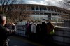 Tourists wear masks as they pause for photos with the New National Stadium, a venue for the opening and closing ceremonies at the Tokyo 2020 Olympics, Sunday, Feb. 23, 2020, in Tokyo. (AP Photo/Jae C. Hong)