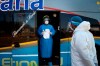A worker from the Paraguayan Public Health Ministry stands after his team conducted passenger control on a bus that was specially organized to bring people from Buenos Aires, Argentina, in the border town of Puerto Falcon, Paraguay, where the border is closed as a measure to curb the spread of COVID-19, Friday, July 10, 2020. Many on the bus were elderly Paraguayans returning home after getting stuck in Argentina where they were visiting relatives at the start of the lockdown. The travelers will quarantine in a government-run shelter in Paraguay before being allowed to continue to their homes. (AP Photo/Jorge Saenz)