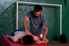 Midfielder Fulvio Duarte of the Fulgencio Yegros football club, massages a volunteer in a gym at San Roque Gonzalez University, in the San Lorenzo district of greater Asuncion, Paraguay, Friday, Feb. 5, 2021. The 31-year-old soccer player who has played for 13 years, is now finishing his studies as a physiotherapist while he works with his wife in an online shop of orthopedic products to survive during the COVID-19 pandemic. (AP Photo/Jorge Saenz)