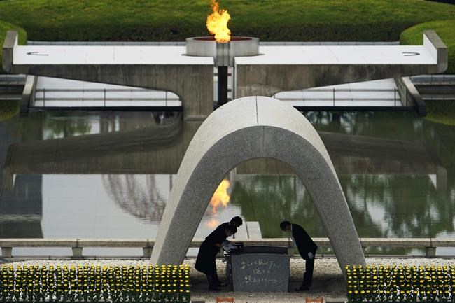 Kazumi Matsui, right, mayor of Hiroshima, and the family of the deceased bow before they place the victims list of the Atomic Bomb at Hiroshima Memorial Cenotaph during the ceremony to mark the 75th anniversary of the bombing at the Hiroshima Peace Memorial Park Thursday, Aug. 6, 2020, in Hiroshima, western Japan. (AP Photo/Eugene Hoshiko)
