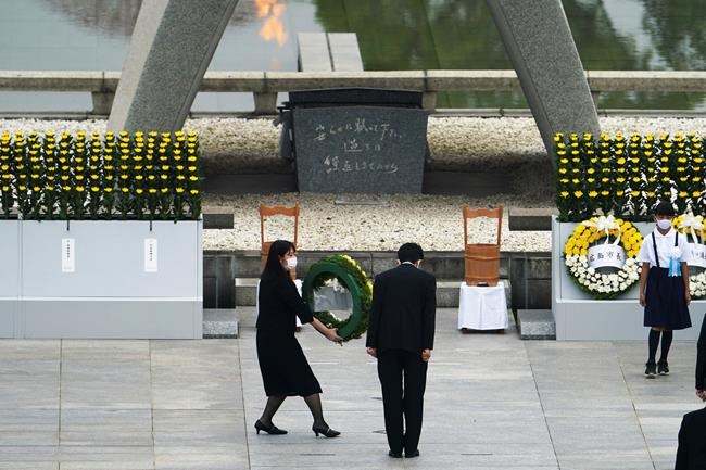 Japanese Prime Minister Shinzo Abe offers flowers to Hiroshima Memorial Cenotaph during a ceremony to mark the 75th anniversary of the bombing at the Hiroshima Peace Memorial Park Thursday, Aug. 6, 2020, in Hiroshima, western Japan. (AP Photo/Eugene Hoshiko)
