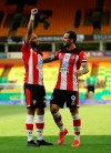 Southampton's Nathan Redmond, left, celebrates with his teammate Danny Ings scoring his side's third goal during the English Premier League soccer match between Norwich City and Southampton at Carrow Road in Norwich, England, Friday, June 19, 2020. (AP Photo/Richard Heathcote/Pool)