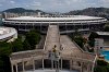 Backdropped by Maracana stadium, firefighter Elielson Silva plays his trumpet from the top of a ladder for residents at home, during a lockdown to help contain the spread of the new coronavirus in Rio de Janeiro, Brazil, Sunday, April 5, 2020. Silva plays tunes known across Brazil, but especially ones composed in and about Rio. (AP Photo/Leo Correa)