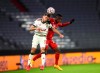 Lokomotiv's Maciej Rybus, left and Bayern's Bouna Sarr, right, fight for the ball during the Champions League Group A soccer match between Bayern Munich and Lokomotiv Moscow at the Allianz Arena in Munich, Germany, Wednesday, Dec. 9, 2020.(AP Photo/Matthias Schrader)
