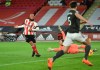 Sheffield United's David McGoldrick, left, shoots to score during the English Premier League soccer match between Sheffield United and Manchester United at the Bramall Lane stadium in Sheffield, England, Thursday, Dec. 17, 2020. (Peter Powell/Pool via AP)