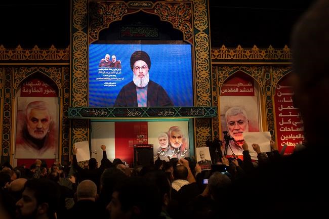Supporters of Hezbollah leader Sayyed Hassan Nasrallah chant slogans as he makes televised remarks at a rally in a southern suburb of Beirut, Lebanon, Sunday, Jan. 5, 2020 following the U.S. airstrike in Iraq that killed Iranian Revolutionary Guard Gen. Qassem Soleimani, seen on a poster at left, and Iraqi Popular Mobilizartiin forces commander Abu Mahdi al-Muhandis, who was also killed. Nasrallah called the killing of Soleimani a