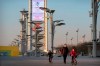 People walk on the Olympic Green near a countdown clock showing slightly more than 1 year to go for the 2022 Beijing Olympics in Beijing, Tuesday, Feb. 2, 2021. A coalition of 180 rights group on Wednesday called for a boycott of next year's Beijing Winter Olympics tied to reported human rights abuses against ethnic minorities in China. (AP Photo/Mark Schiefelbein)