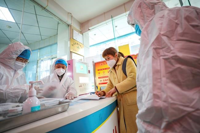 Chinatopix / The Associated Press
Medical workers in protective gear talk with a woman suspected of being ill with a coronavirus at a community health station in Wuhan in central China's Hubei Province, Monday, Jan. 27, 2020. China on Monday expanded sweeping efforts to contain a viral disease by extending the Lunar New Year holiday to keep the public at home and avoid spreading infection. (Chinatopix via AP)