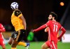 Wolverhampton Wanderers' Willy Boly, left, heads the ball away from Liverpool's Mohamed Salah during the English Premier League soccer match between Wolverhampton Wanderers and Liverpool at Molineux Stadium in Wolverhampton, England, Monday, March. 15, 2021. (AP Photo/Paul Ellis,Pool)