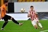 Olympiakos' Kostas Tsimikas, right, kicks the ball during the Europa League round of 16 second leg soccer match between Wolves and Olympiakos at Molineux Stadium in Wolverhampton, England, Thursday, Aug. 6, 2020. (AP Photo/Rui Vieira)