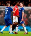 Manchester United's Aaron Wan-Bissaka, centre, reacts with Chelsea's Cesar Azpilicueta, right, and Mateo Kovacic, left, during the English Premier League soccer match between Chelsea and Manchester United at Stamford Bridge in London, England, Monday, Feb. 17, 2020. (AP Photo/Ian Walton)