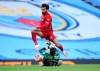 Liverpool's Mohamed Salah leaps over Manchester City's goalkeeper Ederson during the English Premier League soccer match between Manchester City and Liverpool at Etihad Stadium in Manchester, England, Thursday, July 2, 2020. (AP Photo/Laurence Griffiths,Pool)