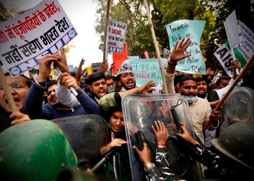 Policemen push back people shouting slogans during a protest held to show support to farmers who have been on a months-long protest, in New Delhi, India, Wednesday, Feb. 3, 2021. Indian authorities Tuesday heavily ramped up security along three main protest sites outside New Delhi's border, using cemented iron spikes, steel barricades and deployed hundreds of police in riot gear in their latest attempt to thwart the growing farmers' protest on the edges of the capital. (AP Photo/Manish Swarup)