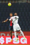 PSG's Presnel Kimpembe and Lyon's Moussa Dembele, right, jump for the ball during the League One soccer match between Paris Saint Germain and Lyon, at the Parc des Princes stadium in Paris, France, Sunday, Dec. 13, 2020. (AP Photo/Thibault Camus)