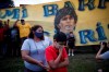 Neighbors gather in front of the house where Diego Maradona was born in the Villa Fiorito neighborhood of Buenos Aires, Argentina, Wednesday, Nov. 25, 2020. The Argentine soccer great who was among the best players ever and who led his country to the 1986 World Cup title before later struggling with cocaine use and obesity, died from a heart attack on Wednesday at his home in Buenos Aires. He was 60.(AP Photo/Natacha Pisarenko)