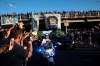 Mourning fans wave from an overpass at the hearse carrying the remains of Diego Maradona to his resting place in Buenos Aires, Argentina, Thursday, Nov. 26, 2020. The Argentine soccer great who was among the best players ever and who led his country to the 1986 World Cup title died from a heart attack at his home Wednesday, at the age of 60. (AP Photo/Rodrigo Abd)