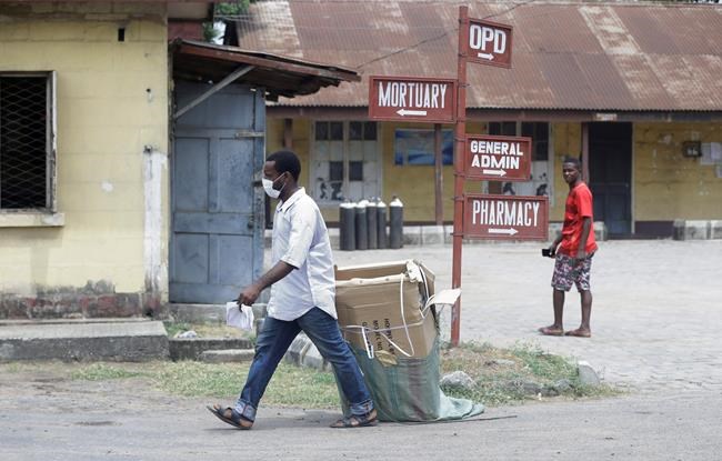A man wearing face mask walks at the Yaba Mainland hospital where an Italian citizen who entered Nigeria on Tuesday from Milan on a business trip, the first case of the COVID-19 virus is being treated in Lagos Nigeria Friday, Feb. 28, 2020. Nigeria's health authorities have reported the country's first case of a new coronavirus in Lagos, the first confirmed appearance of the disease in sub-Saharan Africa. (AP Photo/ Sunday Alamba)