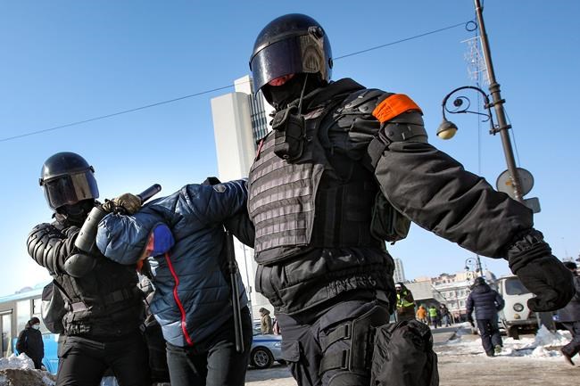 Police officers detain a man during a protest against the jailing of opposition leader Alexei Navalny in Vladivostok, Russia, on Sunday, Jan. 31, 2021. As part of a multipronged effort by the authorities to discourage Russians from attending Sunday's demonstrations, the Prosecutor General's office ordered the state communications watchdog, Roskomnadzor, to block the calls for joining the protests on the internet. (AP Photo/Aleksander Khitrov)
