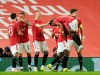 Manchester United players celebrate after Manchester United's Amad Diallo scored his side's opening goal during the Europa League round of 16 first leg soccer match between Manchester United and AC Milan at Old Trafford in Manchester, England, Thursday, March 11, 2021. (AP Photo/Dave Thompson)