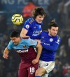 West Ham's Pablo Fornals, left, Leicester's Caglar Soyuncu and Leicester's Ben Chilwell, right, challenge for the ball during the English Premier League soccer match between Leicester City and West Ham Utd at the King Power Stadium in Leicester, England, Wednesday, Jan. 22, 2020. (AP Photo/Rui Vieira)
