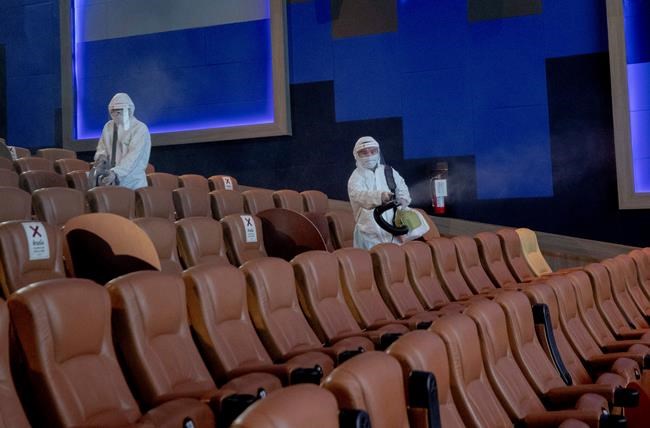 Employees spray disinfectant as a precaution against the coronavirus at the Paragon Cineplex movie theater in Bangkok, Thailand, Monday, June 1, 2020. Thai authorities allowed movie theater and other businesses to reopen, selectively easing restrictions against the coronavirus. (AP Photo/Sakchai Lalit)