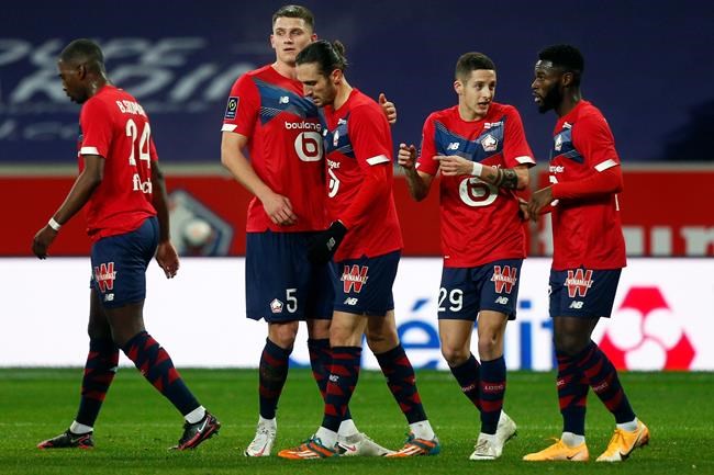 Lille's Yusuf Yazici, centre, celebrates with teammate after he scored his side's first goal during the French League One soccer match between Lille and Dijon at the Stade Pierre Mauroy stadium in Villeneuve d'Ascq, northern France, Sunday, Jan. 31, 2021. (AP Photo/Michel Spingler)