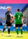 Leicester's goalkeeper Kasper Schmeichel, left, speaks with Brighton's Neal Maupay during the English Premier League soccer match between Leicester City and Brighton & Hove Albion at the King Power Stadium, in Leicester, England, Tuesday, June 23, 2020. (Michael Regan/Pool via AP)