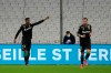 Lens' Simon Banza, left, celebrates after scoring the opening goal of his team during the French League One soccer match between Marseille and Lens at the Veledrome stadium in Marseille, France, Wednesday, Jan. 20, 2021. (AP Photo/Daniel Cole)