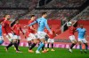 Manchester City's John Stones, center, scores the opening goal of his team during the English League Cup semifinal soccer match between Manchester United and Manchester City at Old Trafford in Manchester, England, Wednesday, Jan. 6, 2021. (Shaun Botterill/Pool via AP)