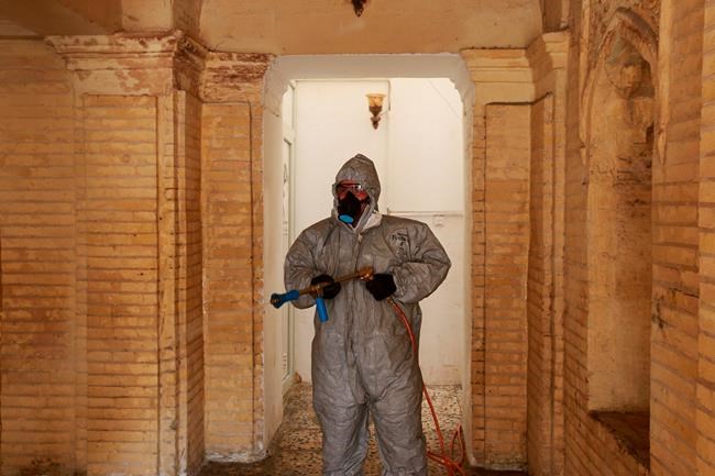 A civil defense worker sprays disinfectant as a precaution against the new coronavirus, inside the Artists Syndicate in Baghdad, Iraq, Wednesday, March 11, 2020. Civil defense staff wearing protective clothing on Wednesday sprayed disinfectant in the public areas of the Iraqi Artists syndicate in an effort to combat coronavirus outbreak. The vast majority of people recover from the new coronavirus. According to the World Health Organization, most people recover in about two to six weeks, depending on the severity of the illness. (AP Photo/Hadi Mizban)