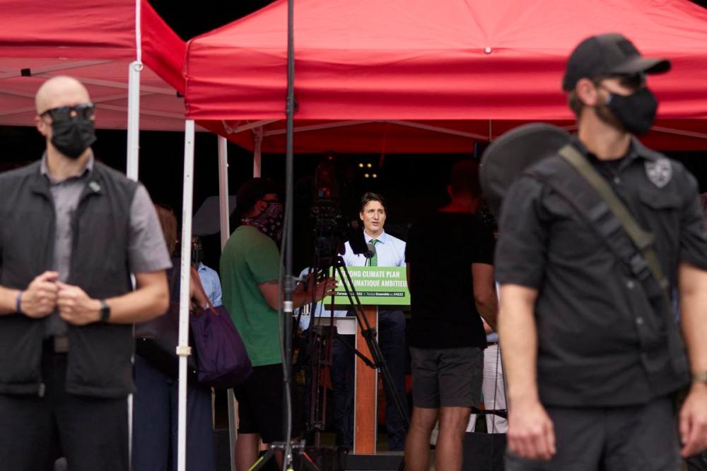 GEOFF ROBINS - AFP via GETTY IMAGES
Police stand guard as Prime Minister Justin Trudeau speaks during a campaign event at VeriForm Inc. in Cambridge, Ontario, on August 29, 2021.