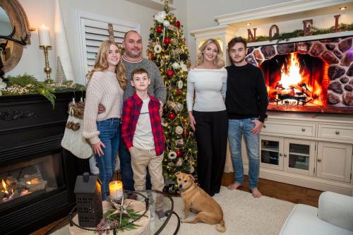 Nick Kozak - for the Toronto Star
Lora and John Currie, with kids Fiona, Jack, and James, and family dog Mr. B., next to one of their home’s many Christmas trees.