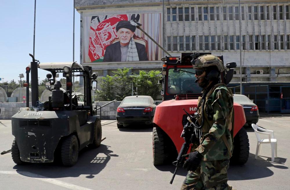 Wali Sabawoon - AP
A Taliban soldier patrols Hamid Karzai International Airport in Kabul, Afghanistan on Sunday. Some domestic flights have resumed at Kabul's airport, with the state-run Ariana Afghan Airlines operating flights to three provinces.