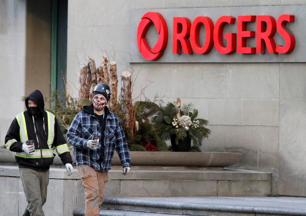 Andrew Francis Wallace - Toronto Star
Construction workers walk past Rogers Communications headquarters in Toronto.