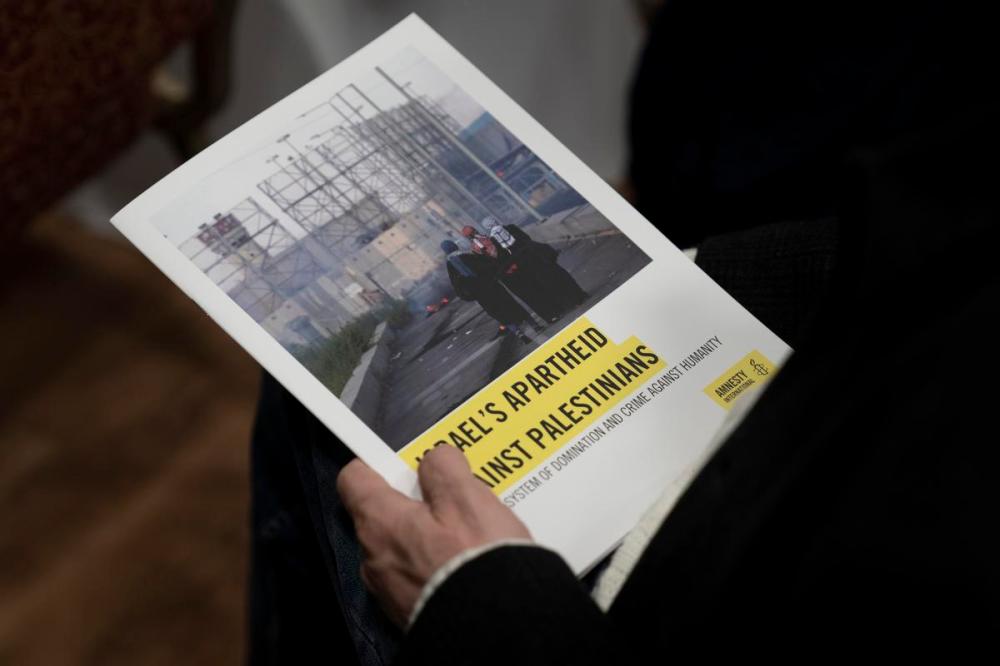 Maya Alleruzzo - AP
A journalist holds a copy of Amnesty International's report