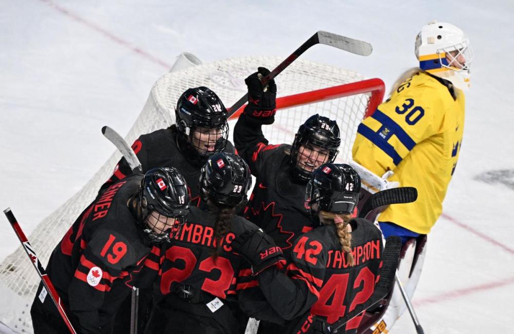 ANTHONY WALLACE - AFP via GETTY IMAGES
Canada's Erin Ambrose celebrates with teammates after scoring the team’s sixth goal past Sweden's goaltender Emma Soderberg during their women's hockey quarterfinal match at the Beijing 2022 Winter Olympic Games.